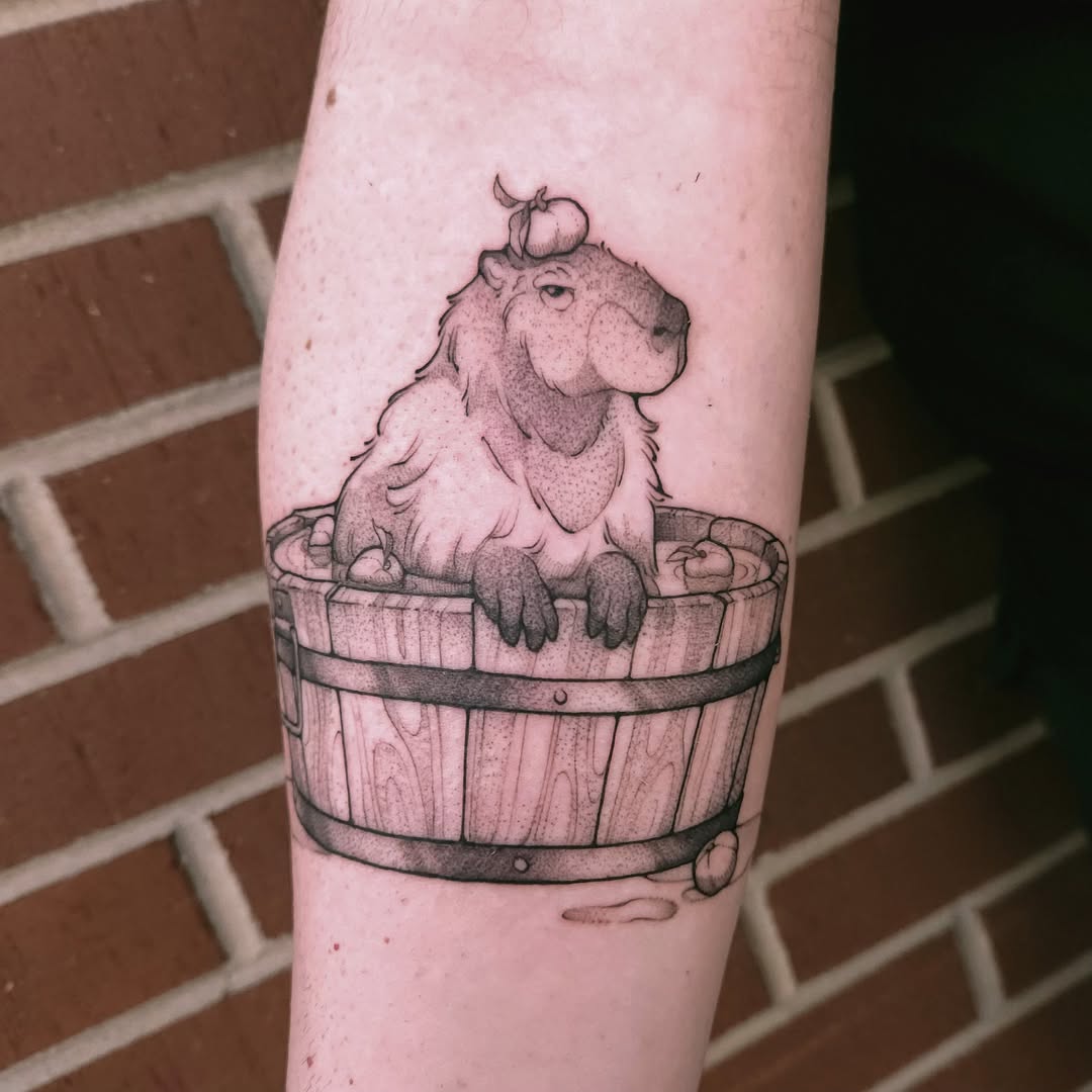 Charming capybara tattoo in a wooden bucket