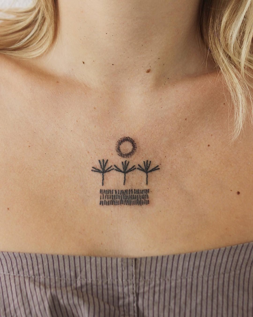 Minimalist growth tattoo with sun and trees
