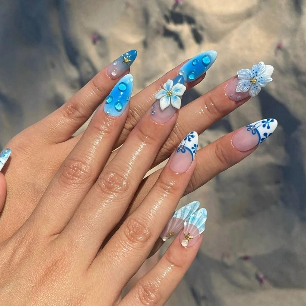 7. Blue Lagoon Floral and Shell Nails (Beach Nail Ideas)